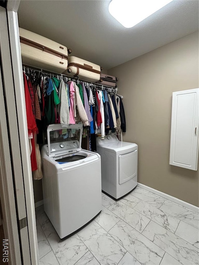laundry room with independent washer and dryer and light marble finish floors
