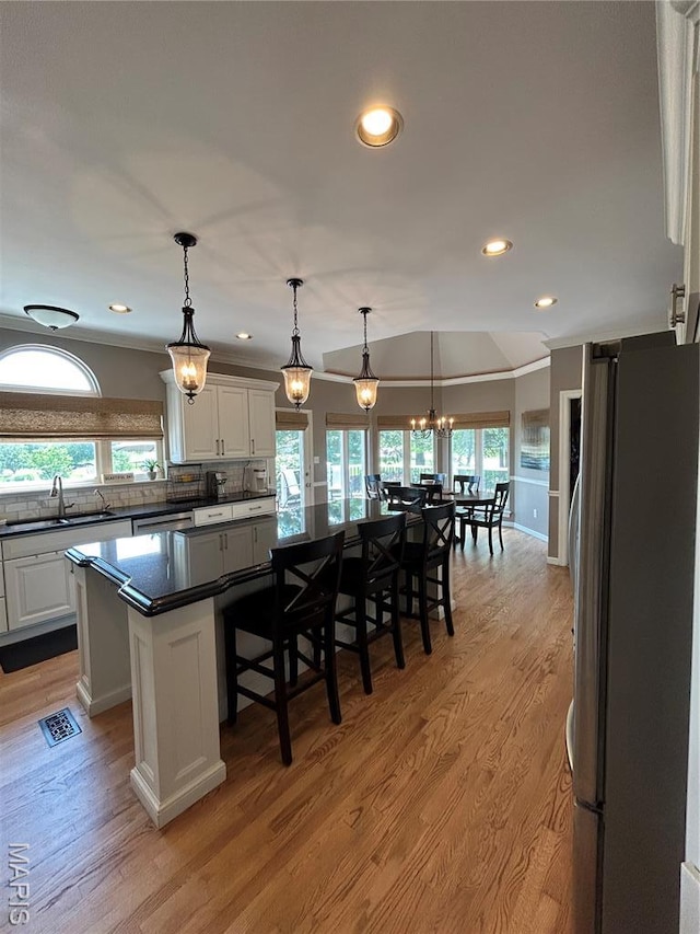 kitchen featuring appliances with stainless steel finishes, dark countertops, a center island, white cabinets, and recessed lighting