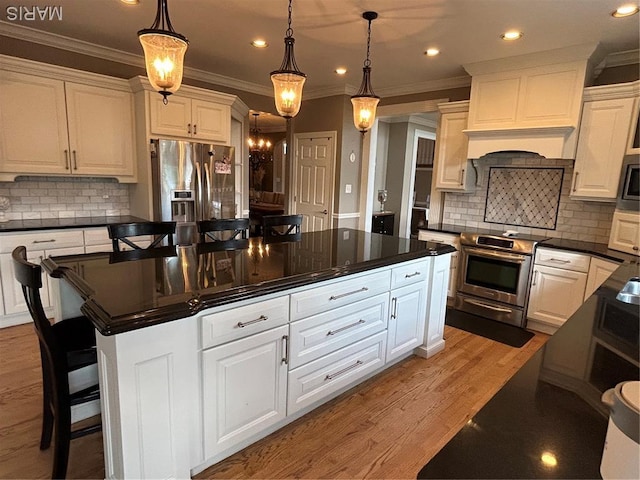 kitchen featuring stainless steel appliances, dark countertops, ornamental molding, recessed lighting, and white cabinetry
