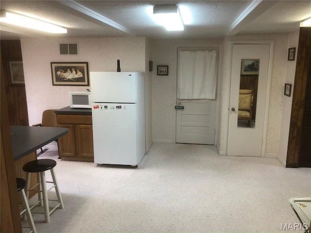 4840 S Point Rd, Washington, MO 63090 - kitchen with white appliances, light colored carpet, dark countertops, brown cabinetry, and a breakfast bar