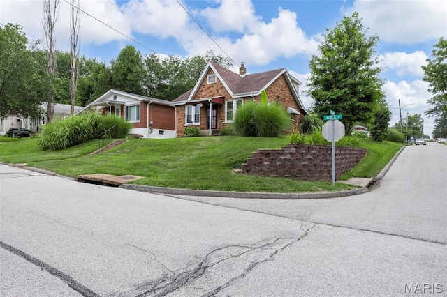 10122 Niblic Dr, Saint Louis, MO 63114 - view of front of home featuring brick siding, a front lawn, and a chimney