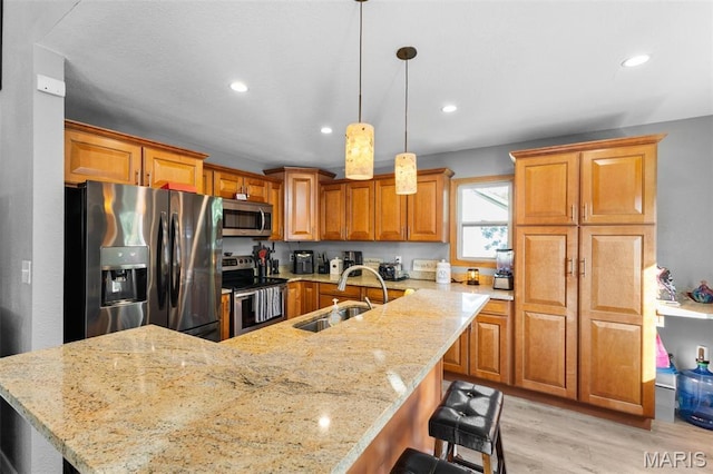 441 Rue Martel, Bonne Terre, MO 63628 - kitchen with stainless steel appliances, light wood-style floors, a breakfast bar area, brown cabinets, and light stone countertops