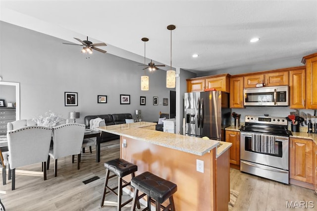 441 Rue Martel, Bonne Terre, MO 63628 - kitchen with stainless steel appliances, ceiling fan, light wood-style flooring, brown cabinets, and a center island