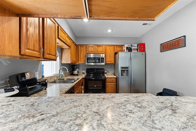 441 Rue Martel, Bonne Terre, MO 63628 - kitchen featuring stainless steel appliances, brown cabinets, recessed lighting, and light stone countertops