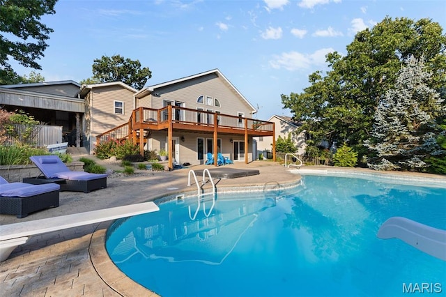 441 Rue Martel, Bonne Terre, MO 63628 - outdoor pool featuring a diving board, a water slide, a wooden deck, a patio area, and stairway