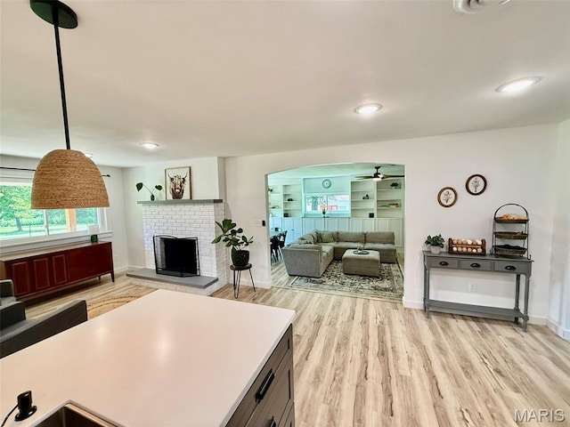 10107 Cannon Mines Rd, Cadet, MO 63630 - living area with light wood-type flooring, arched walkways, ceiling fan, and a brick fireplace