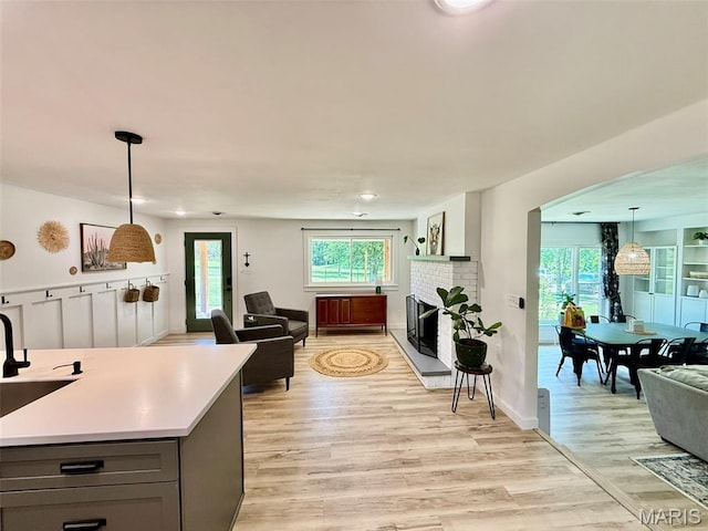 10107 Cannon Mines Rd, Cadet, MO 63630 - living area featuring arched walkways, light wood-style flooring, and a brick fireplace