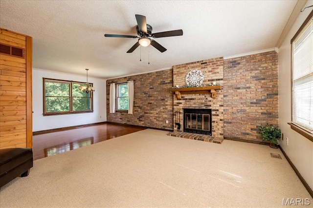 25 Whispering Oaks Dr, Washington, MO 63090 - unfurnished living room with carpet floors, brick wall, ceiling fan, healthy amount of natural light, and a textured ceiling