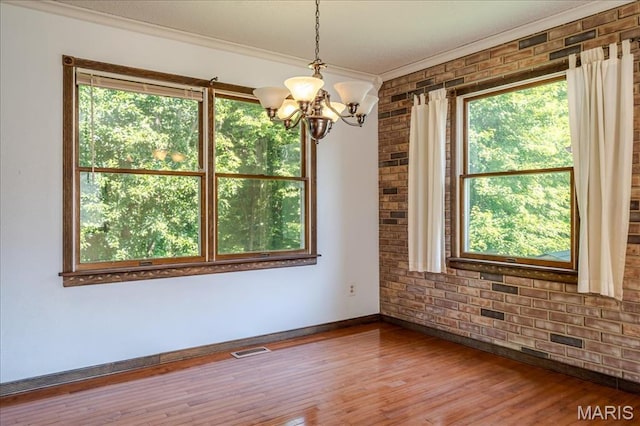 25 Whispering Oaks Dr, Washington, MO 63090 - empty room with ornamental molding, a chandelier, wood finished floors, and brick wall