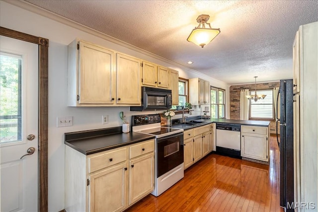 25 Whispering Oaks Dr, Washington, MO 63090 - kitchen featuring black appliances, dark countertops, a chandelier, ornamental molding, and dark wood finished floors