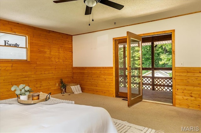 25 Whispering Oaks Dr, Washington, MO 63090 - bedroom with wooden walls, carpet, wainscoting, a textured ceiling, and a ceiling fan