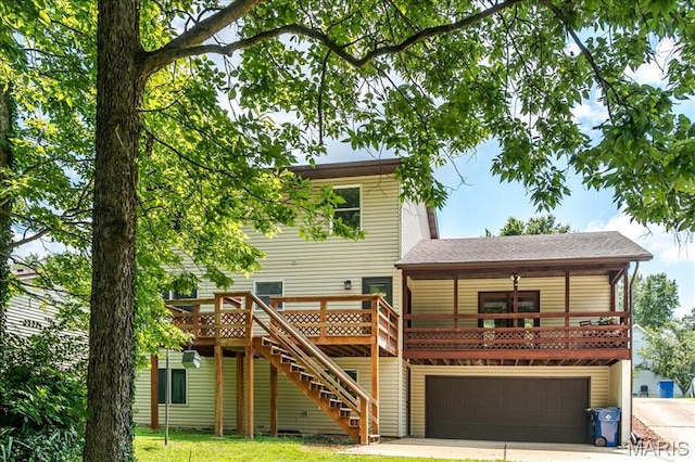 25 Whispering Oaks Dr, Washington, MO 63090 - back of property featuring driveway, stairway, a garage, a wooden deck, and roof with shingles