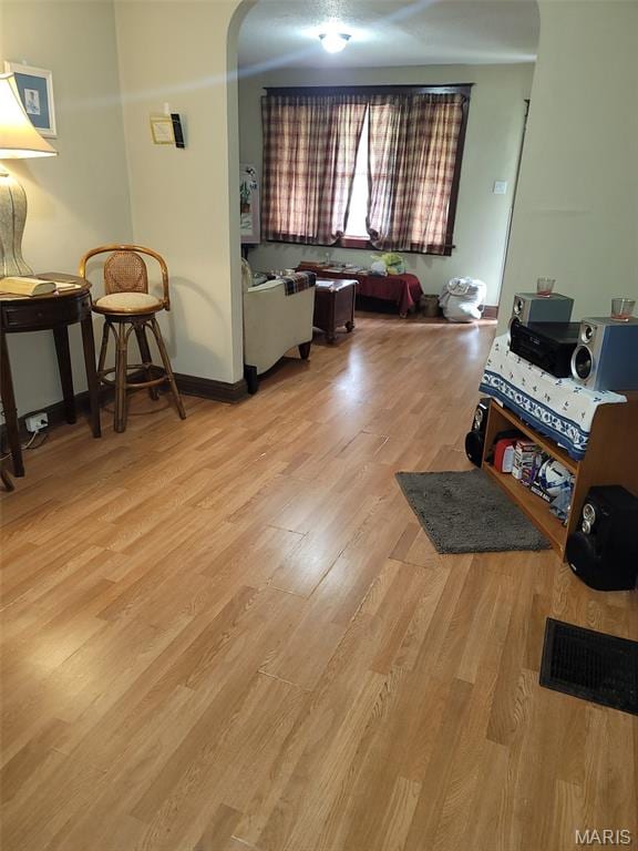 4833 Penrose St, Saint Louis, MO 63115 - living area featuring light wood-style flooring and arched walkways