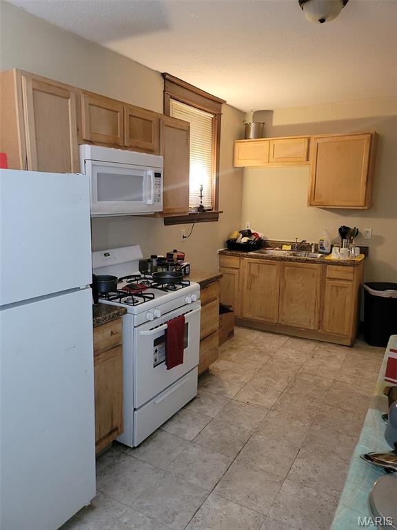 4833 Penrose St, Saint Louis, MO 63115 - kitchen featuring white appliances and light tile patterned floors