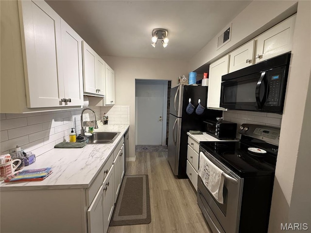 670 Coeur De Royale Dr Unit A, Creve Coeur, MO 63141 - kitchen featuring stainless steel range with electric stovetop, black microwave, light wood-style flooring, decorative backsplash, and white cabinetry
