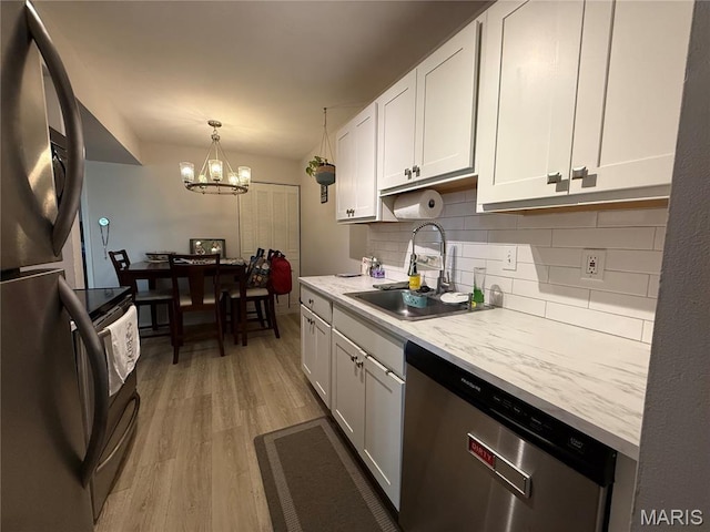 670 Coeur De Royale Dr Unit A, Creve Coeur, MO 63141 - kitchen with stainless steel appliances, decorative backsplash, white cabinets, light wood-type flooring, and a chandelier