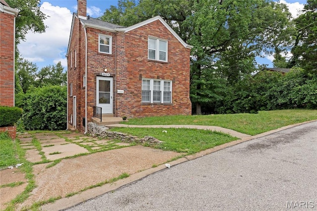 6629 Barken Ave, Northwoods, MO 63121 - view of front of house featuring a chimney, brick siding, and a front yard