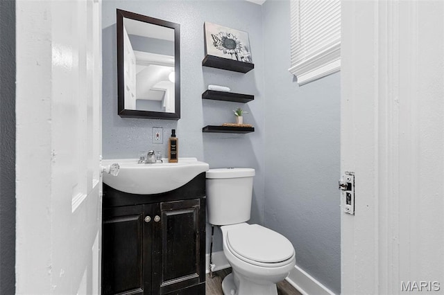 6629 Barken Ave, Northwoods, MO 63121 - half bath with vanity, wood finished floors, and a textured wall