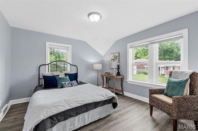 6629 Barken Ave, Northwoods, MO 63121 - bedroom with multiple windows, vaulted ceiling, and wood finished floors