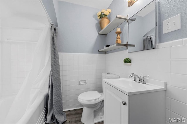 6629 Barken Ave, Northwoods, MO 63121 - full bath featuring tile walls, vanity, wood finished floors, wainscoting, and shower / bathtub combination with curtain