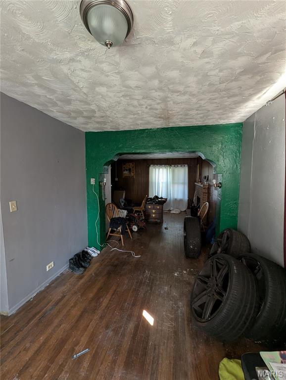 4320 Edgewood Blvd, Saint Louis, MO 63121 - living room featuring arched walkways, wood-type flooring, and a textured ceiling