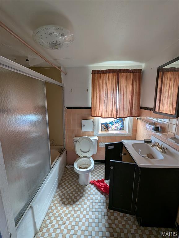4320 Edgewood Blvd, Saint Louis, MO 63121 - kitchen with tile walls, light flooring, a wainscoted wall, brown cabinets, and light countertops