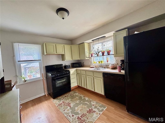 5540 Arthur Ave, Saint Louis, MO 63139 - kitchen featuring black appliances, light countertops, cream cabinetry, and light wood-style flooring