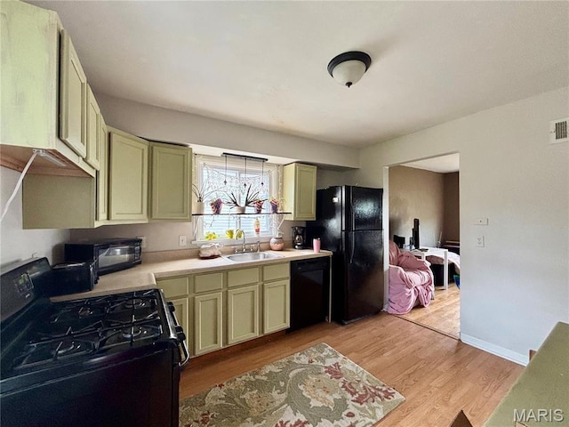 5540 Arthur Ave, Saint Louis, MO 63139 - kitchen featuring black appliances, light wood-style floors, and light countertops