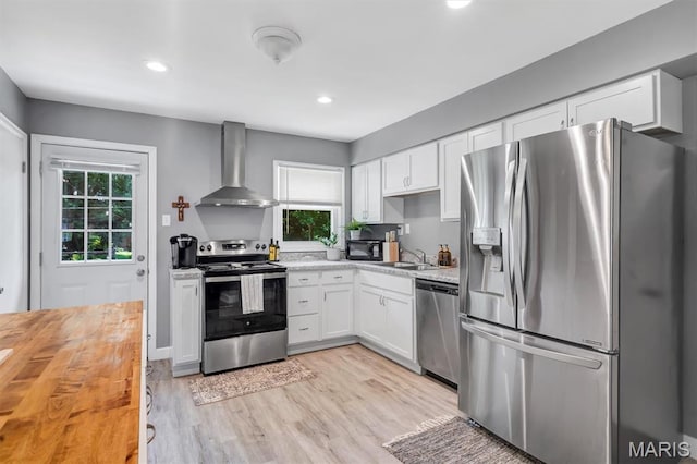 962 Buckeye Dr, Ferguson, MO 63135 - kitchen featuring stainless steel appliances, wall chimney exhaust hood, wood counters, white cabinets, and recessed lighting