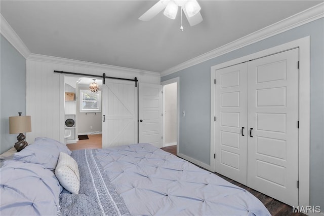 1658 County Road 435, Jackson, MO 63755 - bedroom with a barn door, ornamental molding, a closet, wood finished floors, and a ceiling fan