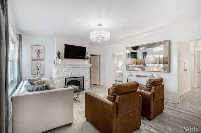 354 Frieda Ave, Kirkwood, MO 63122 - living room featuring ornamental molding, a chandelier, a fireplace, and wood finished floors