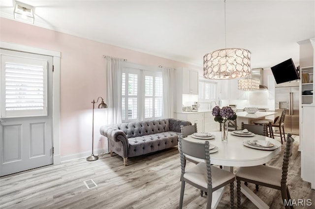 354 Frieda Ave, Kirkwood, MO 63122 - dining space featuring light wood-style flooring, a chandelier, and crown molding
