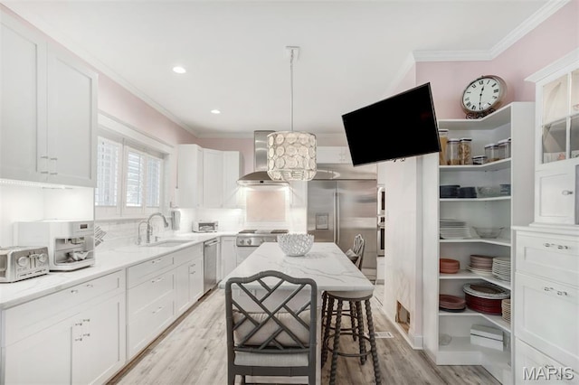 354 Frieda Ave, Kirkwood, MO 63122 - kitchen with wall chimney range hood, appliances with stainless steel finishes, crown molding, white cabinetry, and light stone countertops