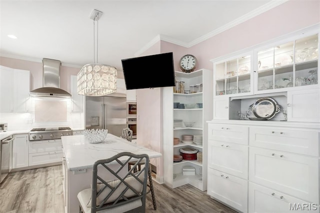 354 Frieda Ave, Kirkwood, MO 63122 - kitchen with appliances with stainless steel finishes, wall chimney range hood, crown molding, light wood finished floors, and white cabinets