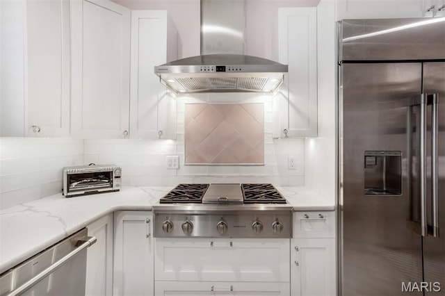 354 Frieda Ave, Kirkwood, MO 63122 - kitchen with appliances with stainless steel finishes, wall chimney range hood, white cabinetry, and backsplash