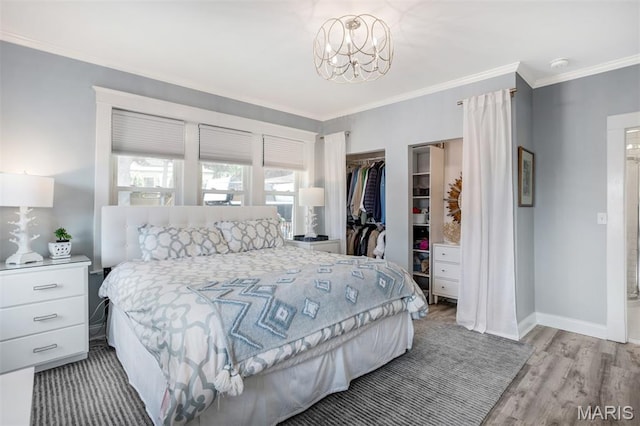 354 Frieda Ave, Kirkwood, MO 63122 - bedroom with crown molding, a spacious closet, light wood-style floors, and a chandelier