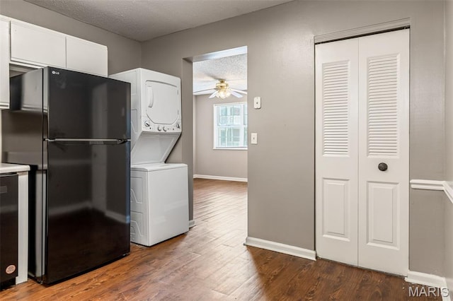 9029 N Swan Cir, Saint Louis, MO 63144 - kitchen featuring stacked washer / drying machine, freestanding refrigerator, ceiling fan, a textured ceiling, and white cabinetry