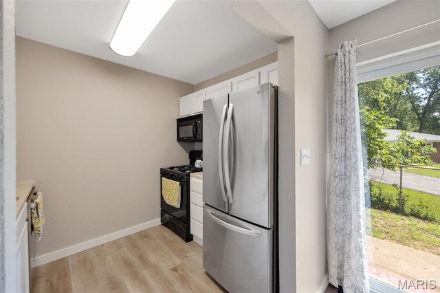 164 Burtonwood Dr, Ballwin, MO 63011 - kitchen featuring black appliances, white cabinetry, light wood-style floors, and light countertops