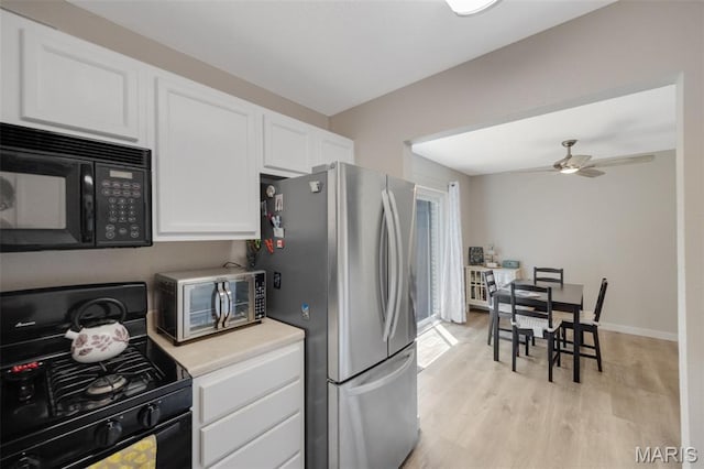 164 Burtonwood Dr, Ballwin, MO 63011 - kitchen featuring black appliances, white cabinetry, light wood-type flooring, light countertops, and a ceiling fan