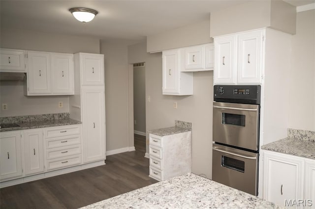 1688 Notre Dame Dr, Bonne Terre, MO 63628 - kitchen with stainless steel double oven, dark wood-style floors, light stone countertops, and white cabinetry