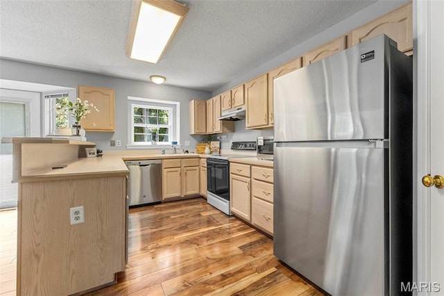 3164 Willow Bend Dr, Saint Charles, MO 63303 - kitchen featuring appliances with stainless steel finishes, light brown cabinets, under cabinet range hood, a peninsula, and light wood-type flooring
