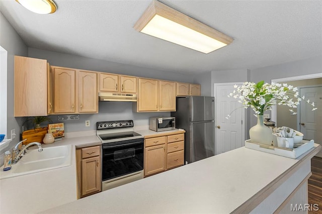 3164 Willow Bend Dr, Saint Charles, MO 63303 - kitchen with appliances with stainless steel finishes, under cabinet range hood, light brown cabinets, light countertops, and a textured ceiling