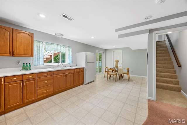 3164 Willow Bend Dr, Saint Charles, MO 63303 - kitchen featuring freestanding refrigerator, light countertops, brown cabinetry, and recessed lighting