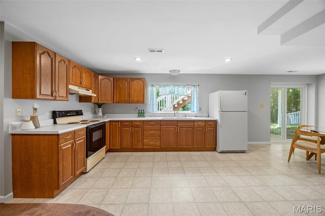 3164 Willow Bend Dr, Saint Charles, MO 63303 - kitchen featuring freestanding refrigerator, range with electric stovetop, under cabinet range hood, brown cabinets, and light countertops