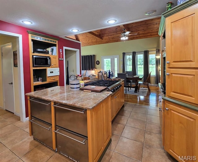 202 Maple, Licking, MO 65542 - kitchen featuring black microwave, light tile patterned flooring, a center island, ceiling fan, and vaulted ceiling