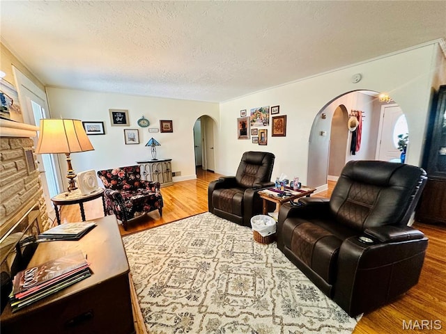 202 Maple, Licking, MO 65542 - living room with arched walkways, wood finished floors, and a textured ceiling