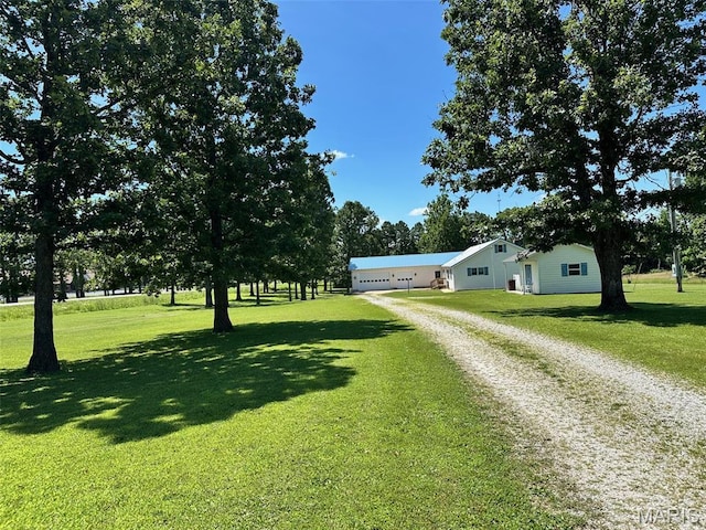 202 Maple, Licking, MO 65542 - view of green lawn featuring driveway and a garage