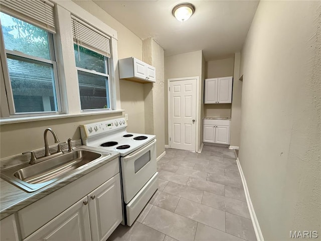 4652 Shirley Pl, Saint Louis, MO 63115 - kitchen with electric range, white cabinets, and light tile patterned floors