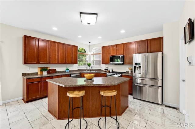 334 Lauren Lndg, Ballwin, MO 63021 - kitchen with appliances with stainless steel finishes, light marble finish floors, dark countertops, a kitchen island, and recessed lighting