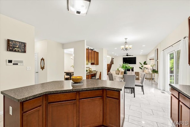 334 Lauren Lndg, Ballwin, MO 63021 - kitchen with dark countertops, a chandelier, light marble finish floors, a center island, and open floor plan